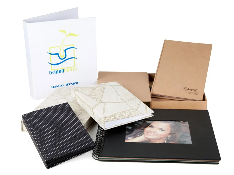 Conjunto de trabalhos encadernados: pasta branca impressa, álbuns pretos, caixas kraft e capas texturizadas