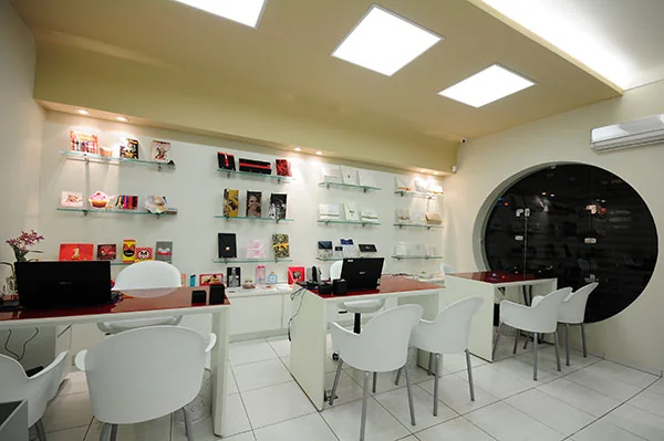 Mesa redonda de atendimento no showroom, cercada de prateleiras com amostras